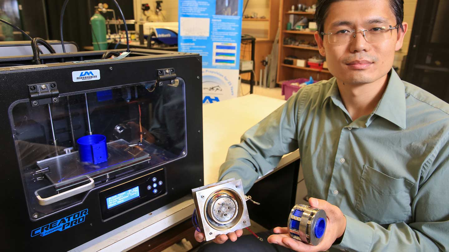 Dr. Gabe Xu holds a hall effect thruster manufactured using 3D printing.